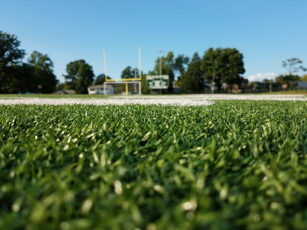 Back to school A bookbag sitting on a football field says school is back in session and its time to learn. tennis ball container stock pictures, royalty-free photos & images