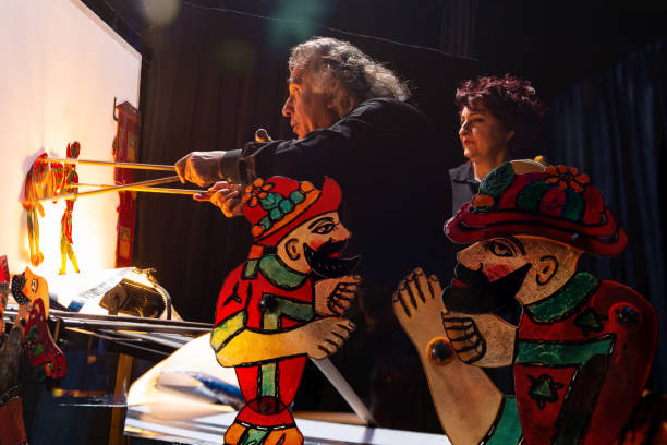 Traditional Turkish shadow play Karagoz and Hacivat Backstage view of a traditional Turkish shadow play Karagoz and Hacivat. Shadow puppet master and his assistant on show. hacivat karagoz stock pictures, royalty-free photos & images