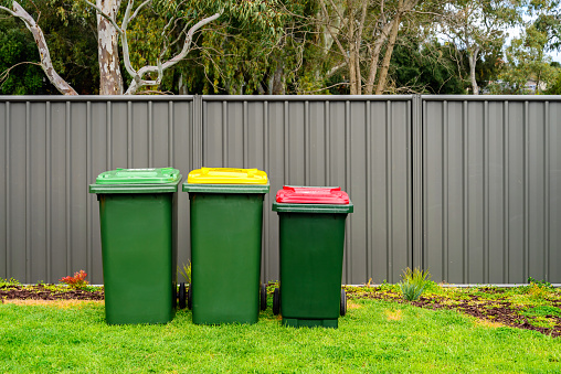 Australian home wheelie bins set provided by local council on back yard in Australian suburb