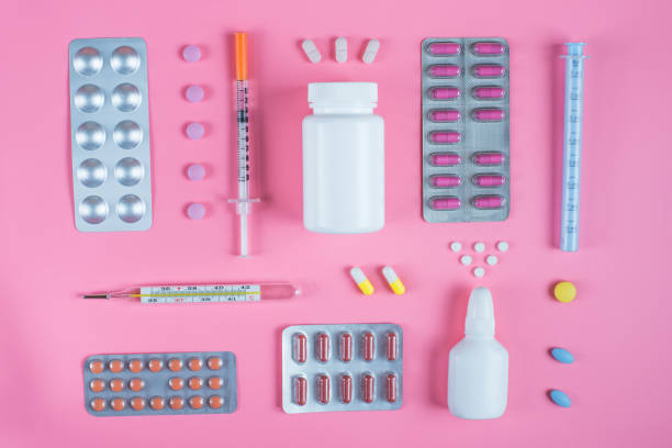 istock Pills in blisters, mercury thermometer and syringe on a pink background. Copy space for text 1127293158