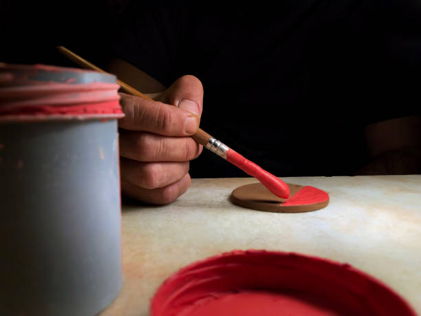 istock Close-up male hands painting on ceramic works 1127294073