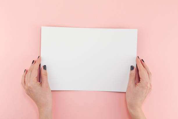 istock Woman hands with blank A4 paper sheet mockup 1127294429