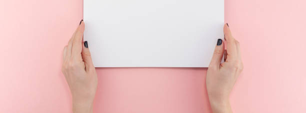istock Woman hands with blank A4 paper sheet mockup 1127294437