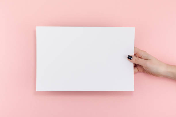 istock Woman hands with blank A4 paper sheet mockup 1127294512
