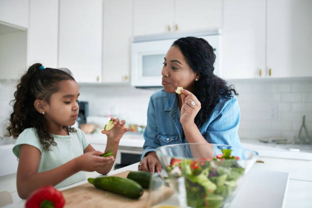 istock Daughter and mother holding zucchini slices 1127294743