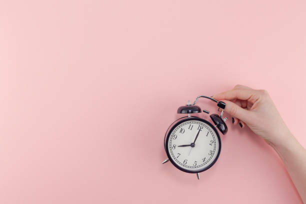 istock Female hand with alarm clock. Morning concept 1127294832