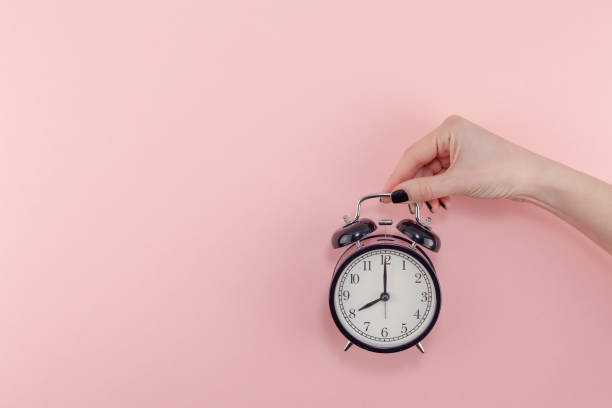 istock Female hand with alarm clock. Morning concept 1127294861