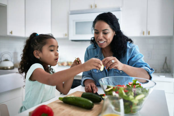 dziewczyna uczy się przygotowywać posiłek od matki - child eating healthy eating healthy lifestyle zdjęcia i obrazy z banku zdjęć