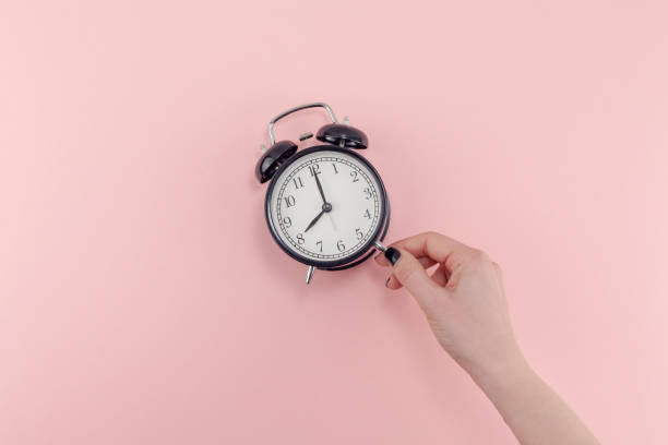 istock Female hand with alarm clock. Morning concept 1127294876
