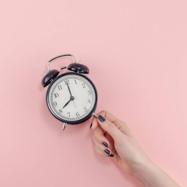 istock Female hand with alarm clock. Morning concept 1127294883