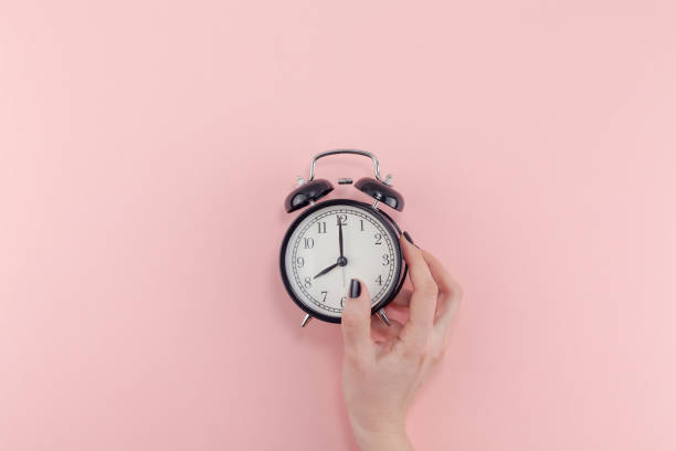 istock Female hand with alarm clock. Morning concept 1127294942