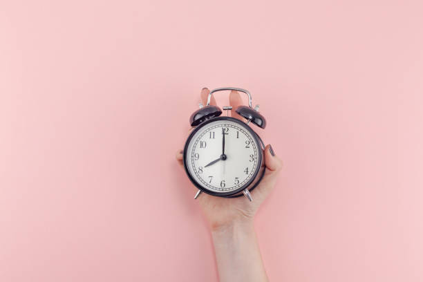 istock Female hand with alarm clock. Morning concept 1127294985