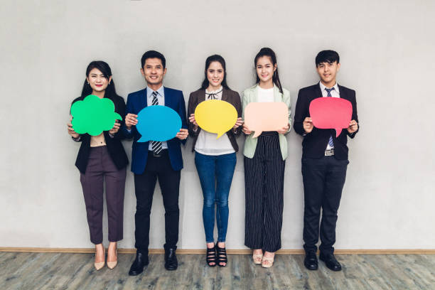 istock Group of business people holding a speech bubble icon 1127296104