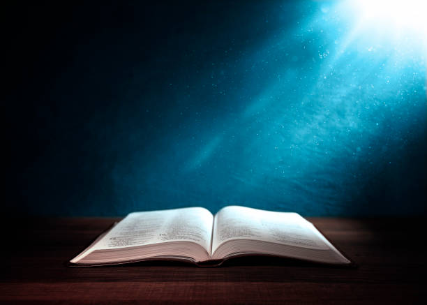 istock Holy Bible illuminated on a  wooden table 1127297685