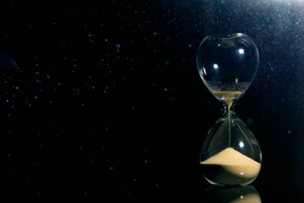istock Isolated hourglass in the dark 1127297689