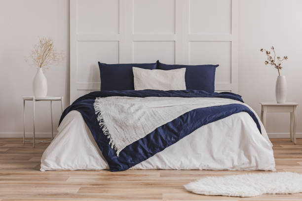 istock White pillow on blue bedding on king size bed in fashionable bedroom interior 1127298971