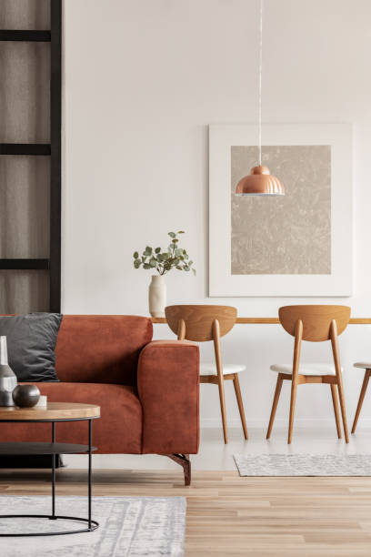 istock Open plan living and dining room interior with long table with chair and brown velvet settee 1127299955