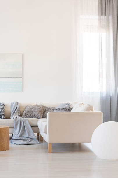 istock Vertical view of bright living room interior with corner sofa with pillows 1127300764