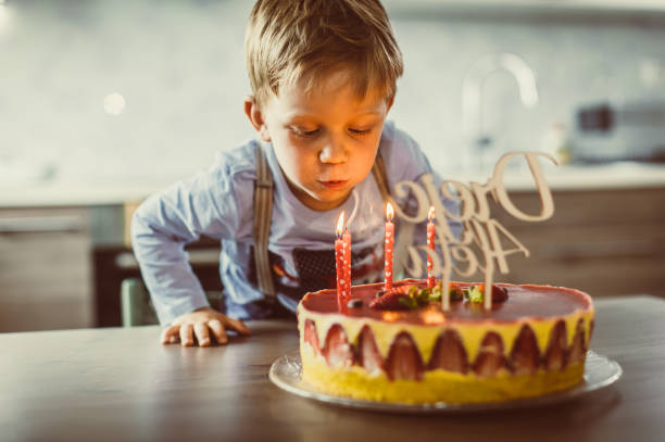 Toddler boy with cake celebrating 4th birthday