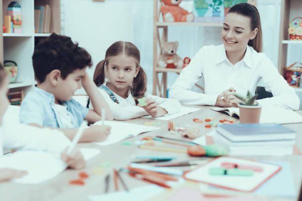 istock Kids in Kindergarten in drawing class with teacher 1127301037