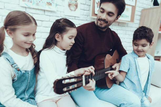 istock music lesson for Kids how to play on guitar 1127301065