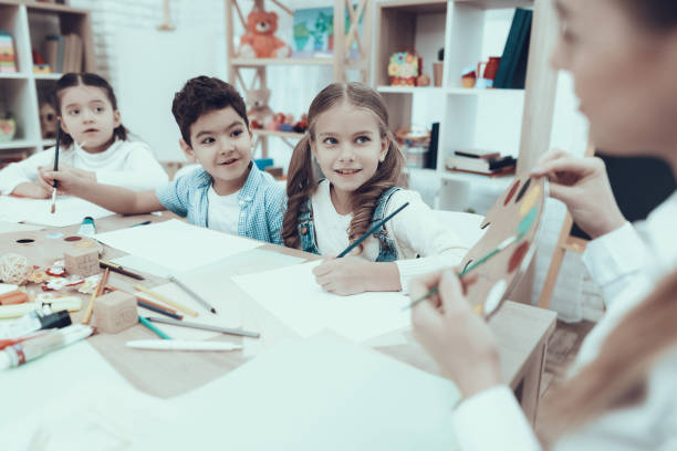 istock Kindergarten teacher shows colors on palette 1127301084