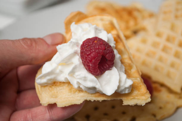 istock waffle in shaped heart with  chantilly cream and raspberry in hand 1127301619