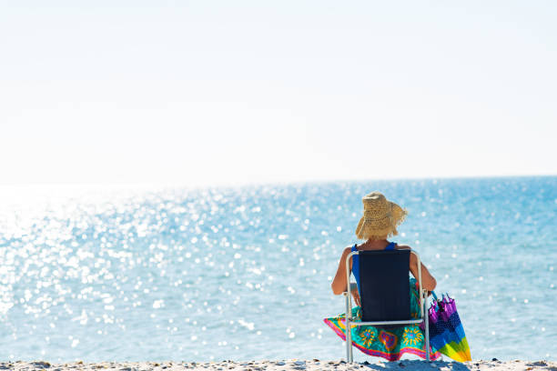 istock Woman in a hat relaxes on a deserted beach 1127302468