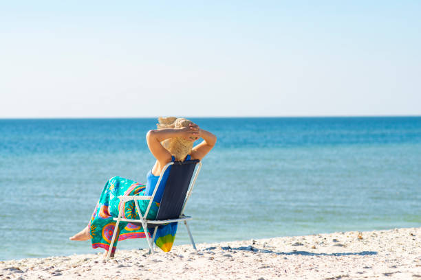 istock Woman in a hat relaxes on a deserted beach 1127302476