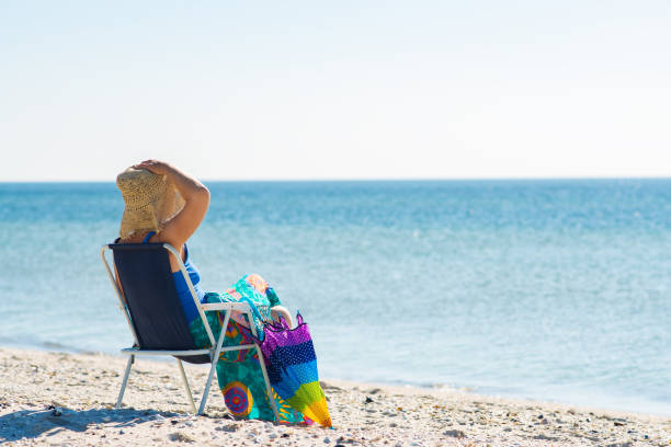 istock Woman in a hat relaxes on a deserted beach 1127302479
