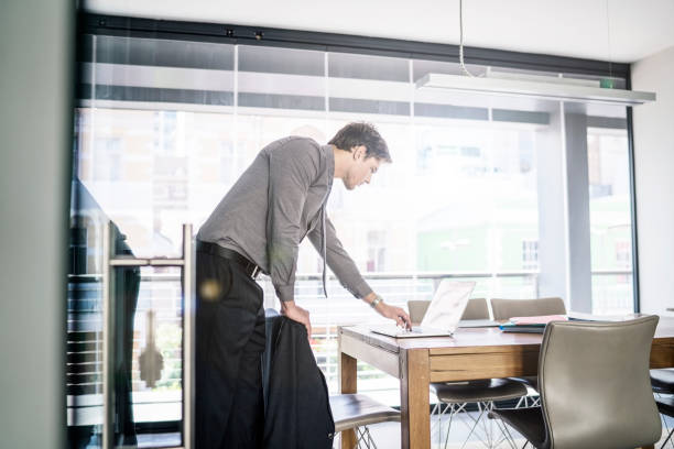 istock Young businessman using laptop at table in office 1127303195