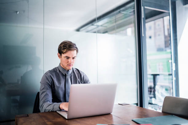 istock Young businessman using laptop in board room 1127303279