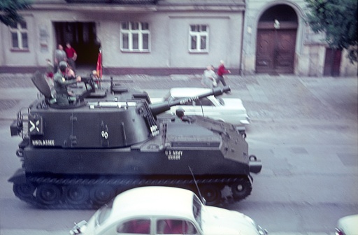 Berlin (West), Germany 1965. Times of the Cold War.  US Army Tank  on the way through the city to a maneuver. Also: buildings and local residents.