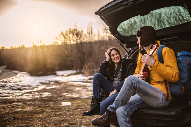 istock Yong couple playing a guitar in car trunk 1127305087