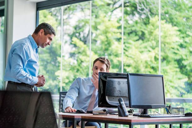istock Businessmen looking at computer on office desk 1127305090