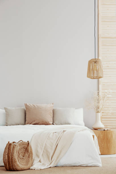 istock King size bed with white and beige decorations, night stand and wicker lamp 1127305104