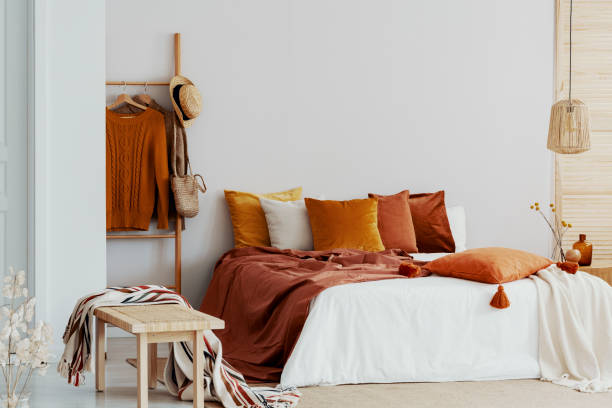 istock Bedroom with king size bed and brown and orange pillows 1127305106