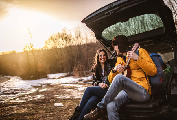 istock Yong couple playing a guitar in car trunk 1127305130