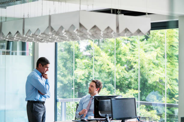 Business professionals discussing by office desk