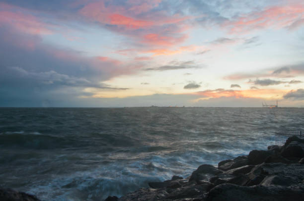 drammatica onda oceanica schizzo la sera con cielo crepuscolare in inverno al breakwater al molo di st kilda a melbourne in australia - melb foto e immagini stock