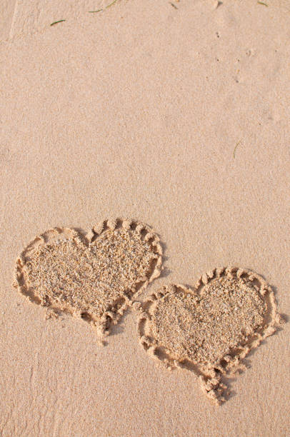istock Two heart shapes in the sand 1127306433
