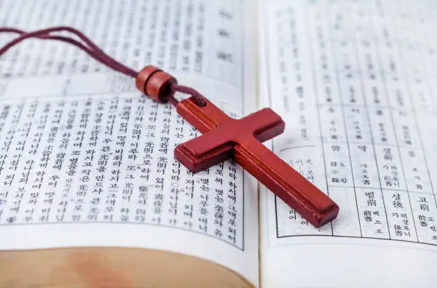 opened-bible-with-woodcross-on-desk