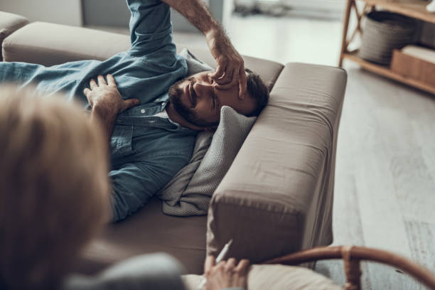 istock Smiling man resting on the sofa and touching his forehead 1127307760