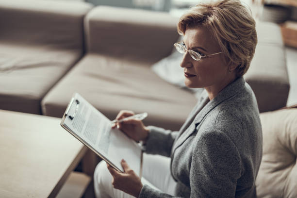 istock Confident psychologist sitting with straight back and holding notes 1127307790