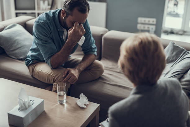 istock Sad man crying while sitting with his psychologist 1127307817