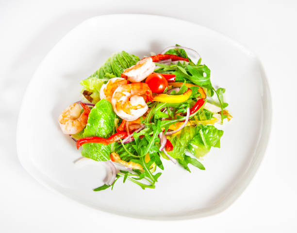 istock Delicious salad with shrimp, tomatoes and greenery on white 1127311089