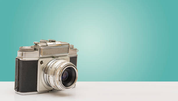istock Vintage Camera Side View on A Wooden Ground 1127311463