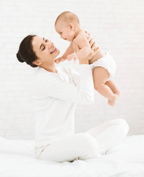 young mom holding her happy baby in air - mother enjoyment built structure human head imagens e fotografias de stock