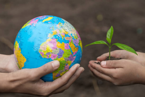 istock Adults holding a globe and child hand holding a small seedling, plant a tree, reduce global warming, World Environment Day 1127312678