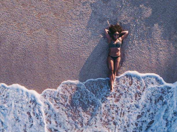 istock Mixed race woman resting at the beach 1127313069